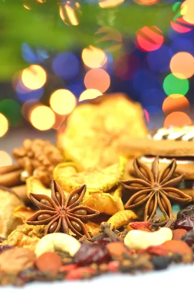 Christmas spices, nuts, cookies and dried fruits on bokeh background — Stock Photo, Image