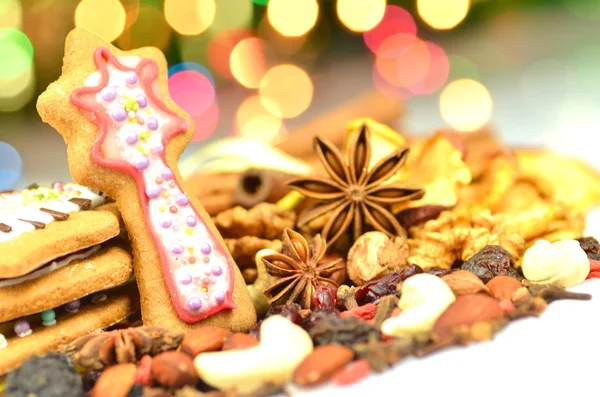 Weihnachtsgewürze, Nüsse, Plätzchen und Trockenfrüchte auf Bokeh-Hintergrund — Stockfoto