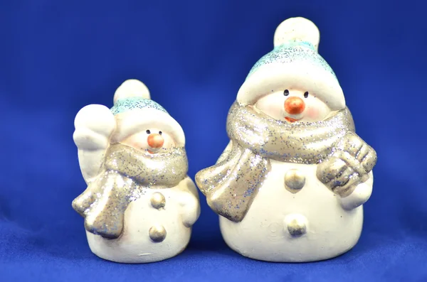 Weihnachtsdekoration, zwei Schneemannfiguren auf blauem Hintergrund — Stockfoto