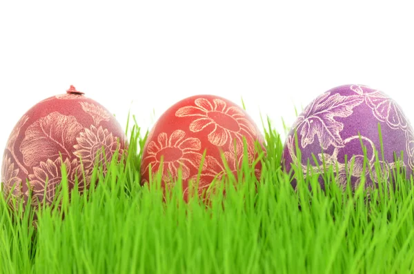 Three scratched handmade Easter eggs in the grass isolated on white background — Stock Photo, Image