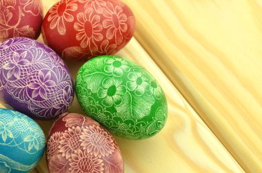 Colorful scratched handmade Easter eggs on a table clipart