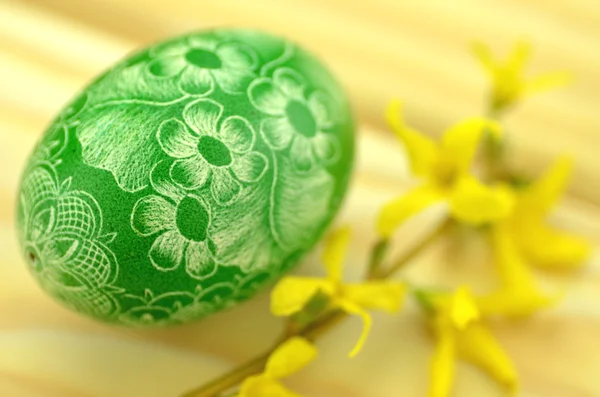 Tradicional arranhado artesanal ovo de Páscoa e flores forsythia — Fotografia de Stock