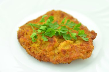 bir tabakta ekmekli domuz pirzolası