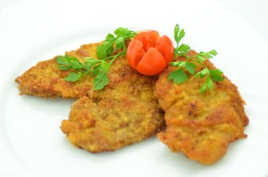 bir tabakta ekmekli domuz pirzolası