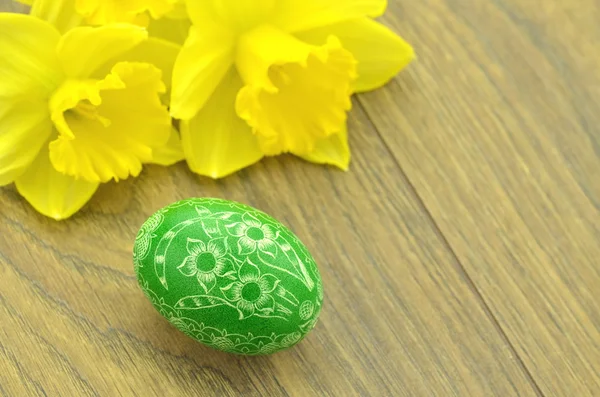 Scratched handmade Easter egg and daffodil flowers — Stock Photo, Image