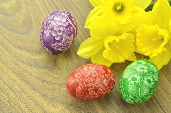Huevos de Pascua hechos a mano y flores de narciso — Foto de Stock