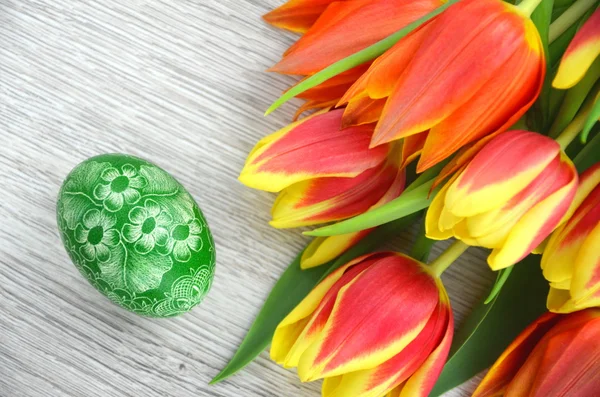 Gekrast handgemaakte paasei en tulp bloemen — Stockfoto