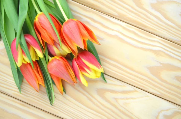 Um buquê de tulipas em uma mesa de madeira — Fotografia de Stock