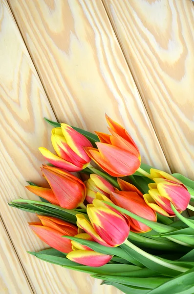 Um buquê de tulipas em uma mesa de madeira — Fotografia de Stock