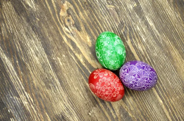 Hermosos huevos de Pascua hechos a mano arañados en una mesa de madera — Foto de Stock