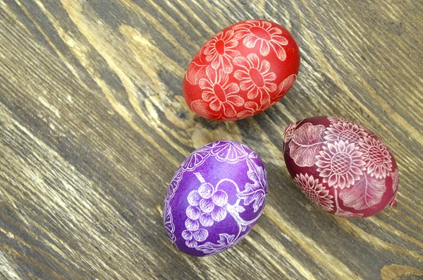 Hermosos huevos de Pascua hechos a mano arañados en una mesa de madera — Foto de Stock