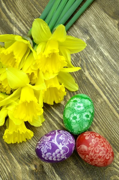 Beautiful scratched handmade Easter eggs and daffodil flowers — Stock Photo, Image