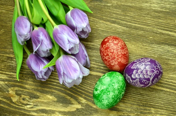 Scratched handmade Easter eggs and tulip flowers — Stock Photo, Image