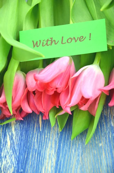 Mit Liebeswünschen und einem Strauß wunderschöner roter Tulpen — Stockfoto