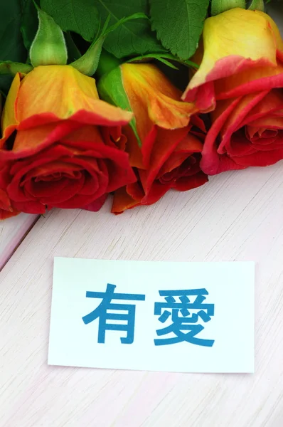 Con deseos de amor en chino y ramo de hermosas rosas rojas —  Fotos de Stock