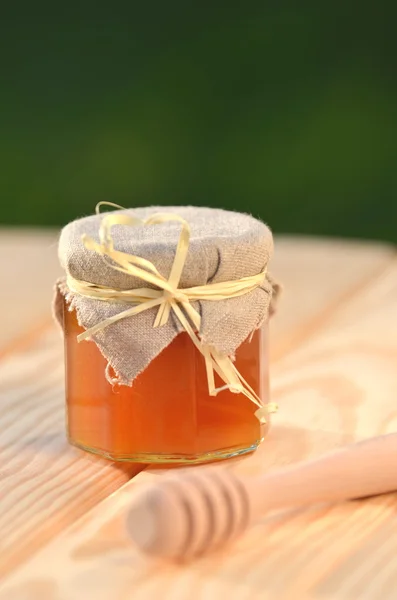 Olla de miel de madera y tarro lleno de deliciosa miel fresca en colmenar —  Fotos de Stock