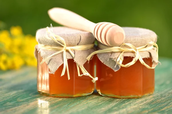 Tarro de deliciosa miel con flores de colza y cazo de miel —  Fotos de Stock