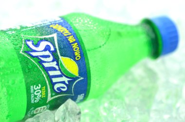 Bottle of Sprite drink on ice cubes clipart