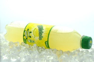 Bottle of Mirinda drink on ice cubes clipart