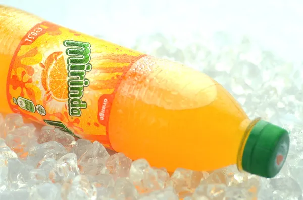 Bottle of Mirinda drink on ice cubes — Stock Photo, Image