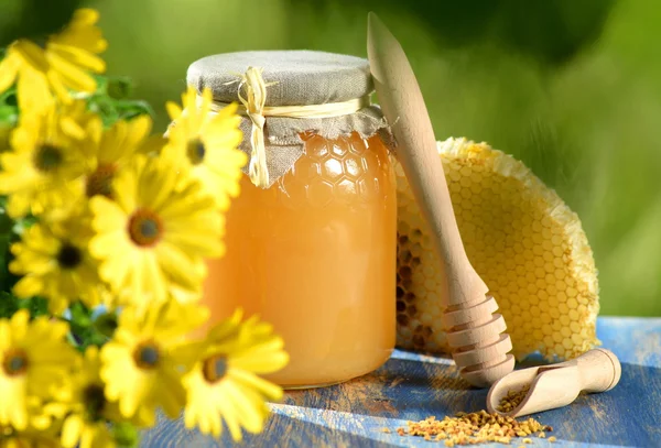 Jar full of delicious honey, honeycomb and bee pollen in apiary — Stock Photo, Image