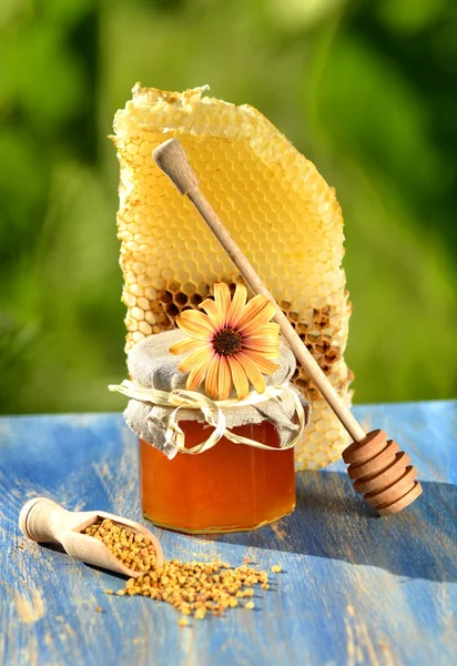 Słoik pełen pysznego miodu, plaster miodu i pszczoła pyłek w pasieki — Zdjęcie stockowe