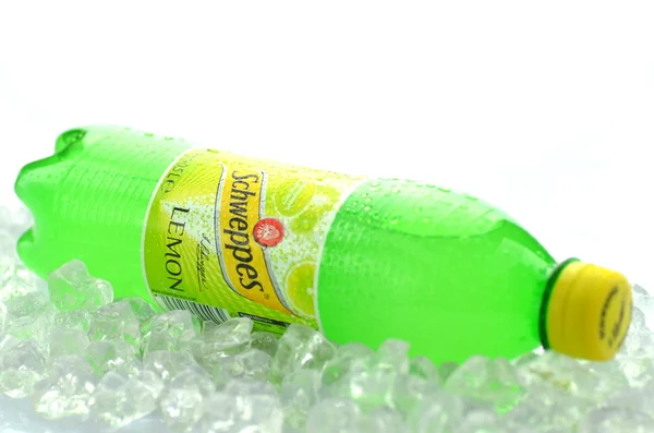 Bottles of Schweppes drink on ice cubes — Stock Photo, Image