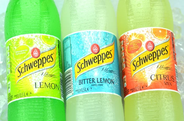 Bottles of Schweppes drink on ice cubes — Stock Photo, Image