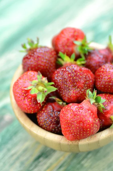 Fresas frescas y deliciosas en un tazón sobre una mesa — Foto de Stock