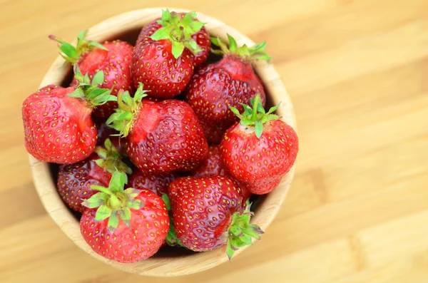 Fresas frescas y deliciosas en un tazón sobre una mesa — Foto de Stock