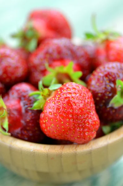 Fresas frescas y deliciosas en un tazón sobre una mesa — Foto de Stock