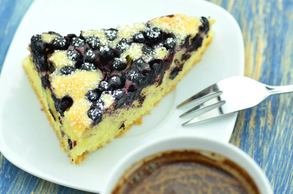 Piece of delicious homemade fruity sponge cake with blueberries and cup of coffee — Stock Photo, Image