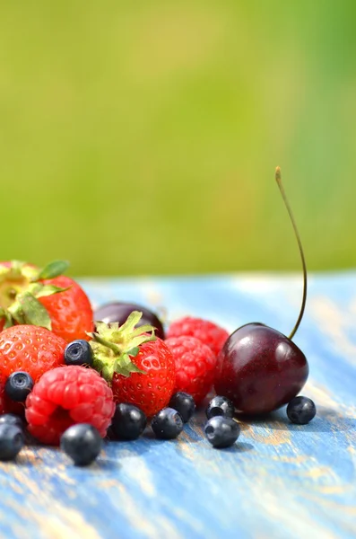 Variedad de frutas suaves, fresas, frambuesas, cerezas, arándanos en la mesa en el jardín — Foto de Stock