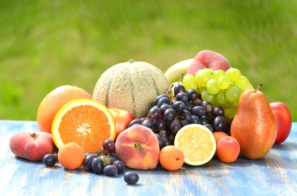 Variety of fruits on table in the garden — Stock Photo, Image