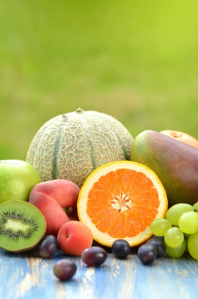 Różne owoce na stole w ogrodzie — Zdjęcie stockowe