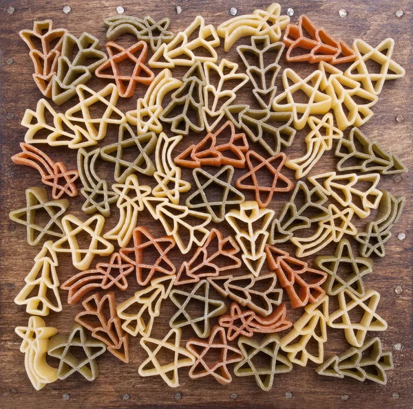 Färgade okokt pasta på träbord — Stockfoto