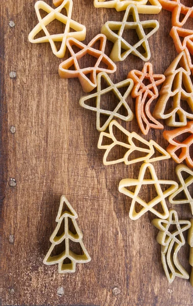 Colored uncooked pasta on wooden table — Stock Photo, Image