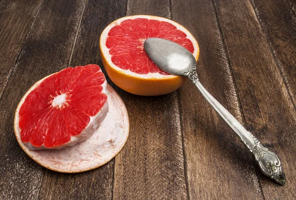 Свежий, спелый, органический полугрейпфрут с ложкой на деревянном фоне — стоковое фото