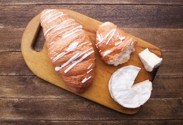 Croissant e formaggio su tavola di legno — Foto Stock