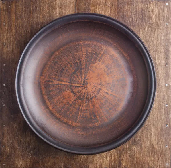 Placa marrón vacía sobre mesa de madera — Foto de Stock