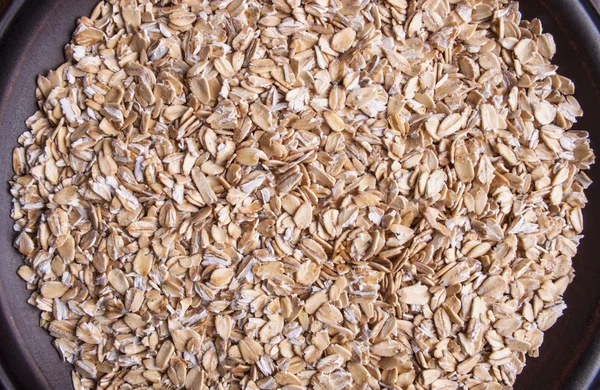 Plate with raw oatmeal background — Stock Photo, Image
