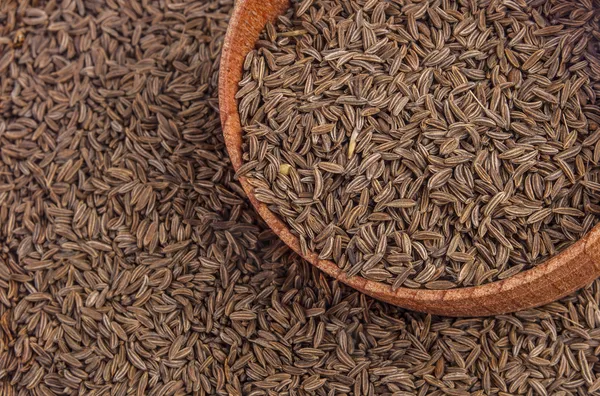 Semillas de comino en un plato de madera — Foto de Stock