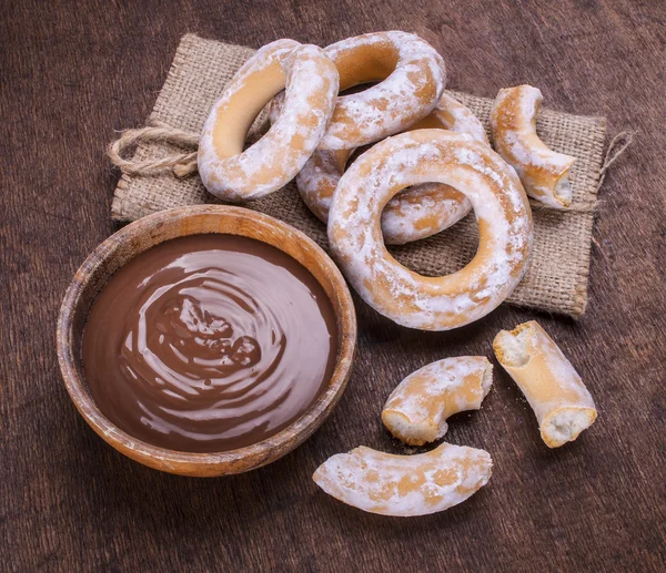 Schokoladencreme und Bagels auf dunklem Holz Hintergrund — Stockfoto