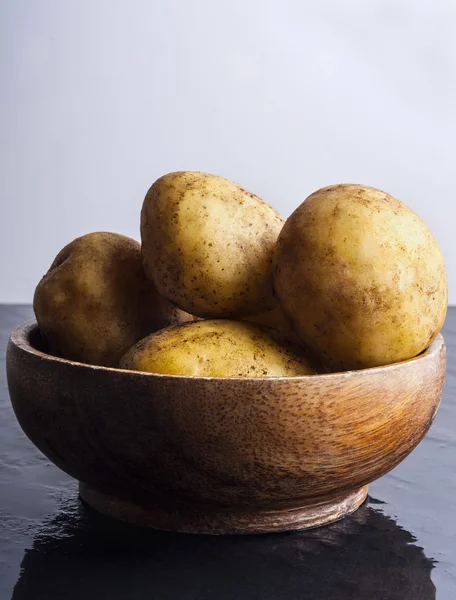 Surowe ziemniaki w misce na kamiennym stole — Zdjęcie stockowe