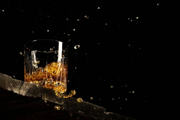 Whisky Glas Auf Schwarzem Hintergrund Auf Einem Holztisch lizenzfreie Stockbilder