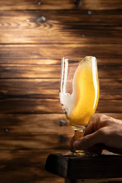 Vidro com cerveja lager no fundo de madeira — Fotografia de Stock