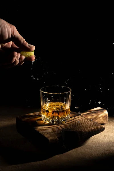 Whisky w szklance na czarnym tle na drewnianym stole — Zdjęcie stockowe