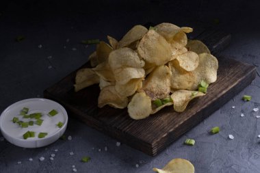 Gri beton arka planda doğal patates cipsi.