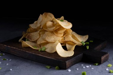 Gri beton arka planda doğal patates cipsi.