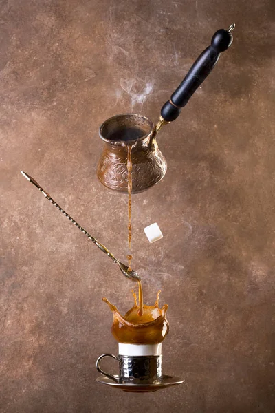 コーヒーとタークを茶色の背景で浮遊させます。コーヒーのスプラッシュ。トルココーヒー. — ストック写真